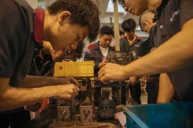 健雄学院中德班的学生在实训车间拆装机器